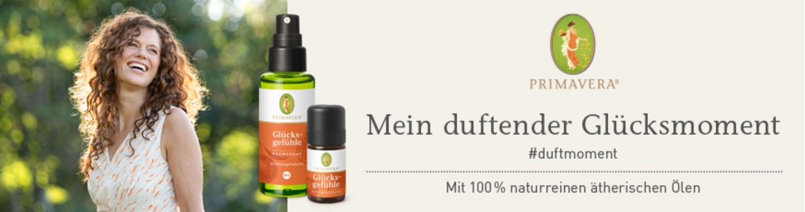 Links eine lachende Frau mit braunen gelockten Haaren im Grünen, rechts das Logo von Primavera, darunter "Mein duftender Glücksmoment"