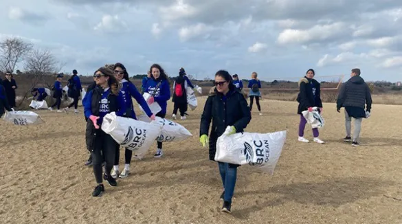 Freiwillige sammeln am Strand Müll ein