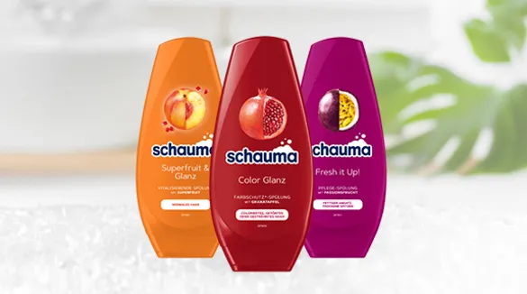 Schauma Spülung, drei Flaschen: Superfruit & Glanz mit Vitaminen, Color Glanz für Farbschutz mit Granatapfel-Extrakt und Fresh it Up! mit Passionsfrucht-Extrakt. Haarpflegeprodukte für glänzendes und gepflegtes Haar, präsentiert vor einem weichen, natürlichen Hintergrund.