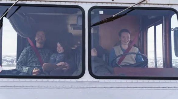 Eltern mit zwei Kindern sitzen in großem Auto