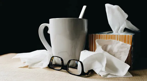 Brille-weiße-Tasse-Tempobox-Taschentücher-dunkler-Hintergrund