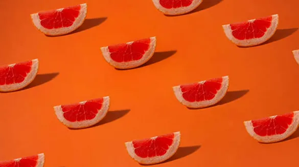 Grapefruitschnitze-oranger-Hintergrund