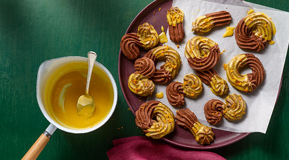 Dunkles Spritzgebäck mit Orangen-Kurkuma-Glasur